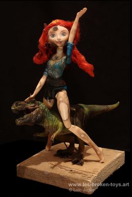 N°79: la rousse et le dinosaure vert
						Création 2026
						Dimensions: 30X15X19 cm. 
						Auteur; Loïc Jugue
						Technique : Poupée rousse  chevauchant un dinosaure vert, les deux ont été brûlés au chalumeau, socle en bois de chantier. 
